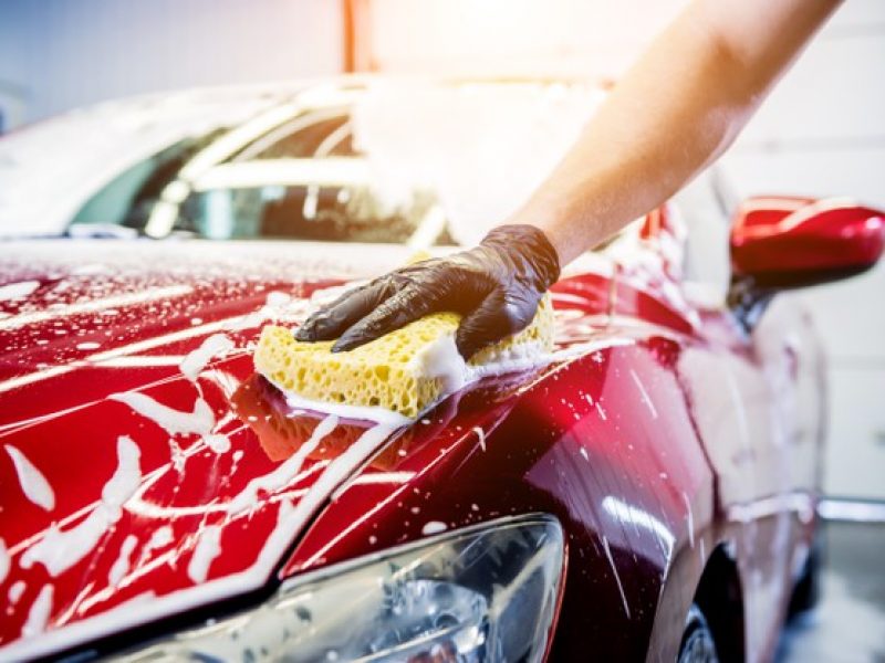 worker-washing-red-car-with-sponge-car-wash_179755-10792